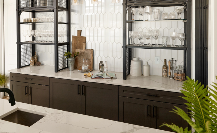 Marble countertop with dark cabinets, glassware, and bar tools in a modern setup.